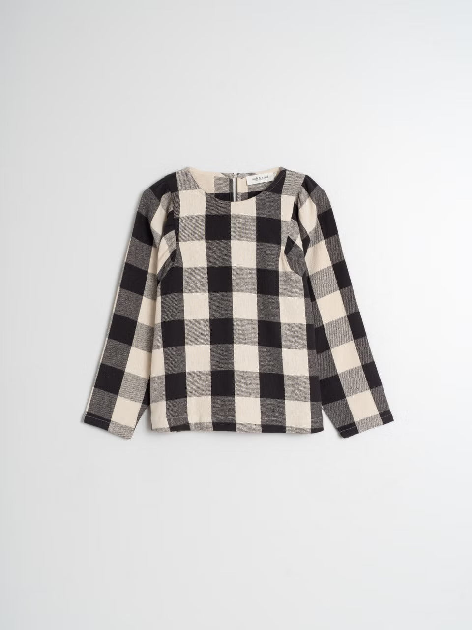 This black and cream gingham shirt by Indi &amp; Cold isn't afraid to make a statement. Made with 100% cotton flannel, it offers both comfort and style. The rouch puff sleeve detail adds a touch of playfulness, while the tailored fit keeps it looking polished. Dare to be bold with this large print gingham shirt.