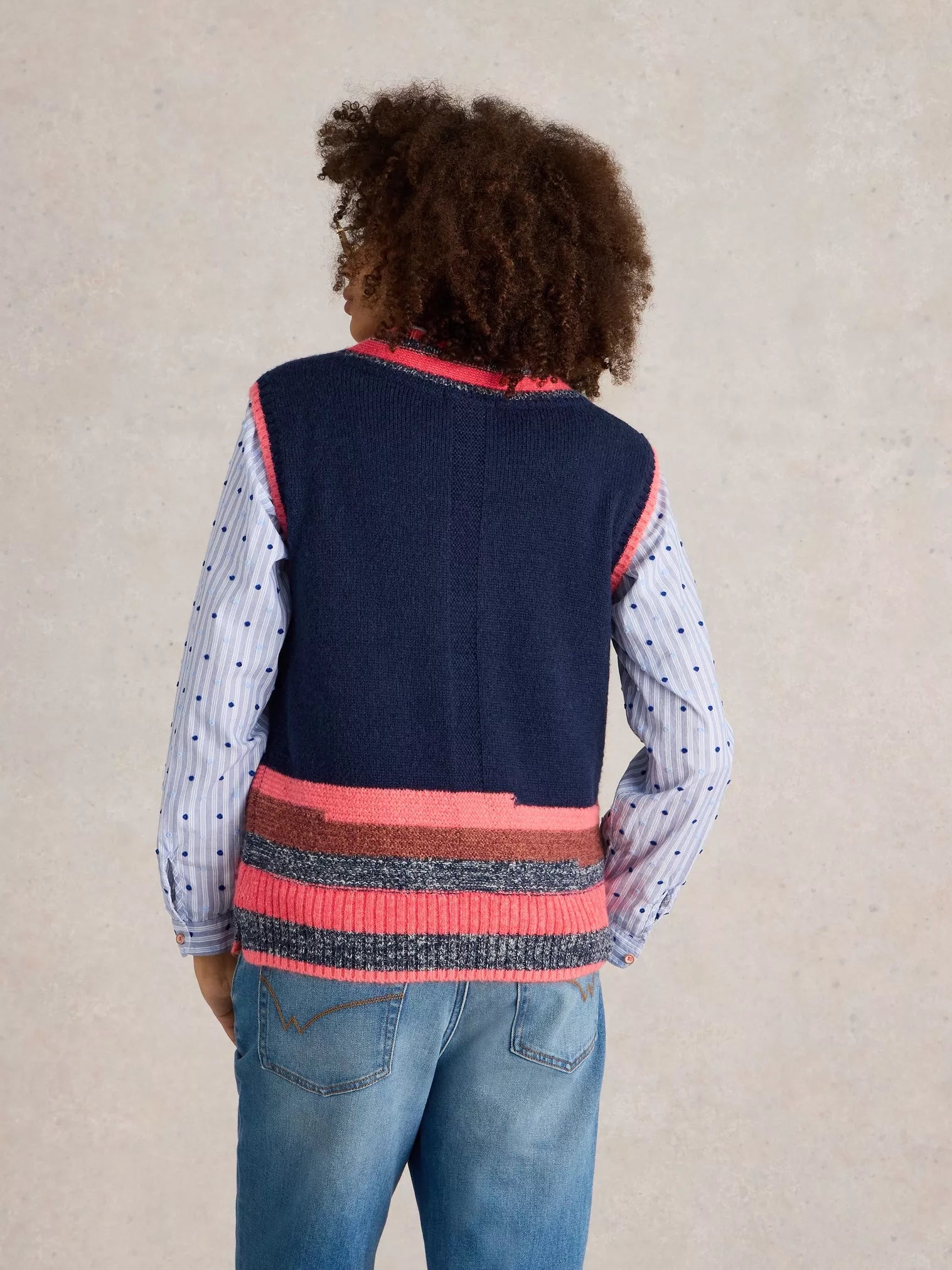 Be a standout in this cool V Neck Striped Vest by White Stuff. With a touch of quirkiness (the best ones always have it), this deep blue knitted vest features a unique mismatched stripe at the bottom and playful bright coral and pink tones at the top. 