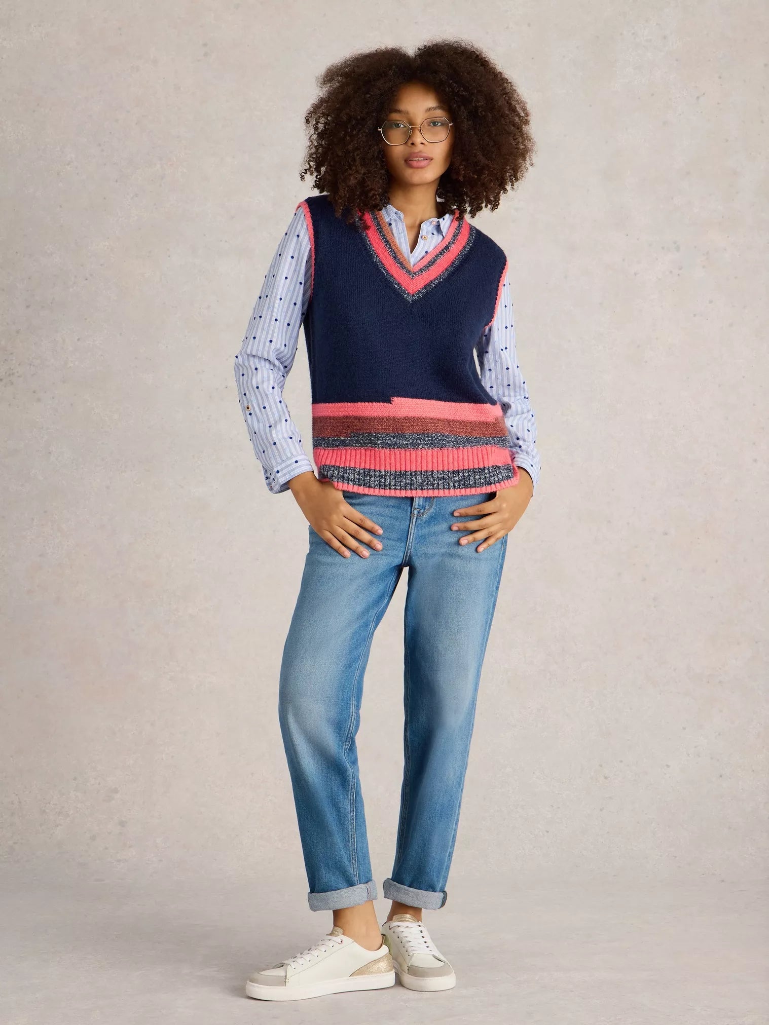 Be a standout in this cool V Neck Striped Vest by White Stuff. With a touch of quirkiness (the best ones always have it), this deep blue knitted vest features a unique mismatched stripe at the bottom and playful bright coral and pink tones at the top. 