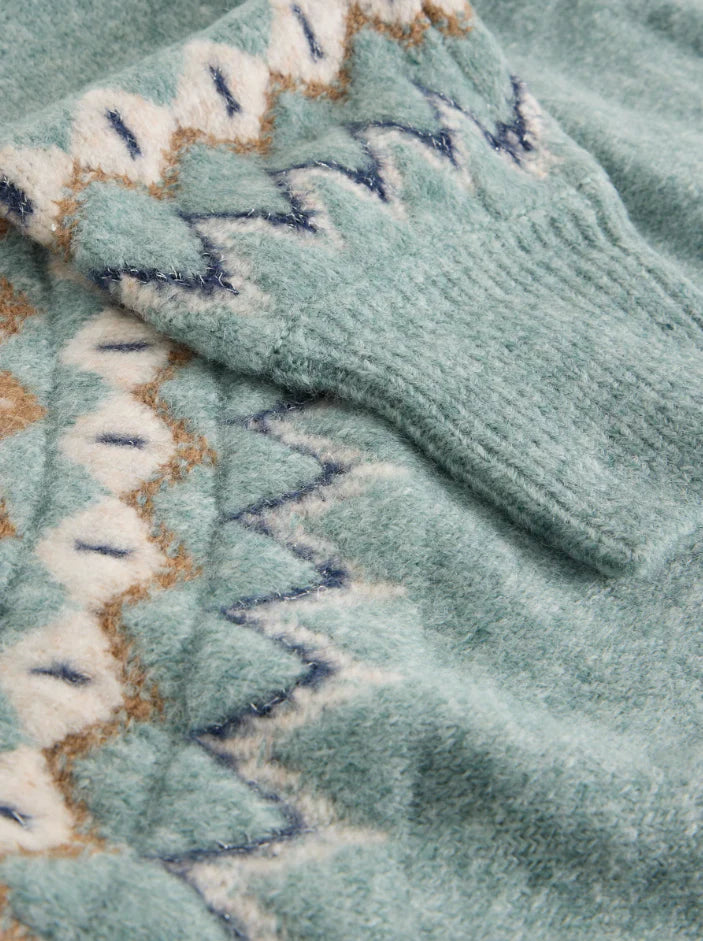 Close-up of a textured fabric with a patterned border on a teal background