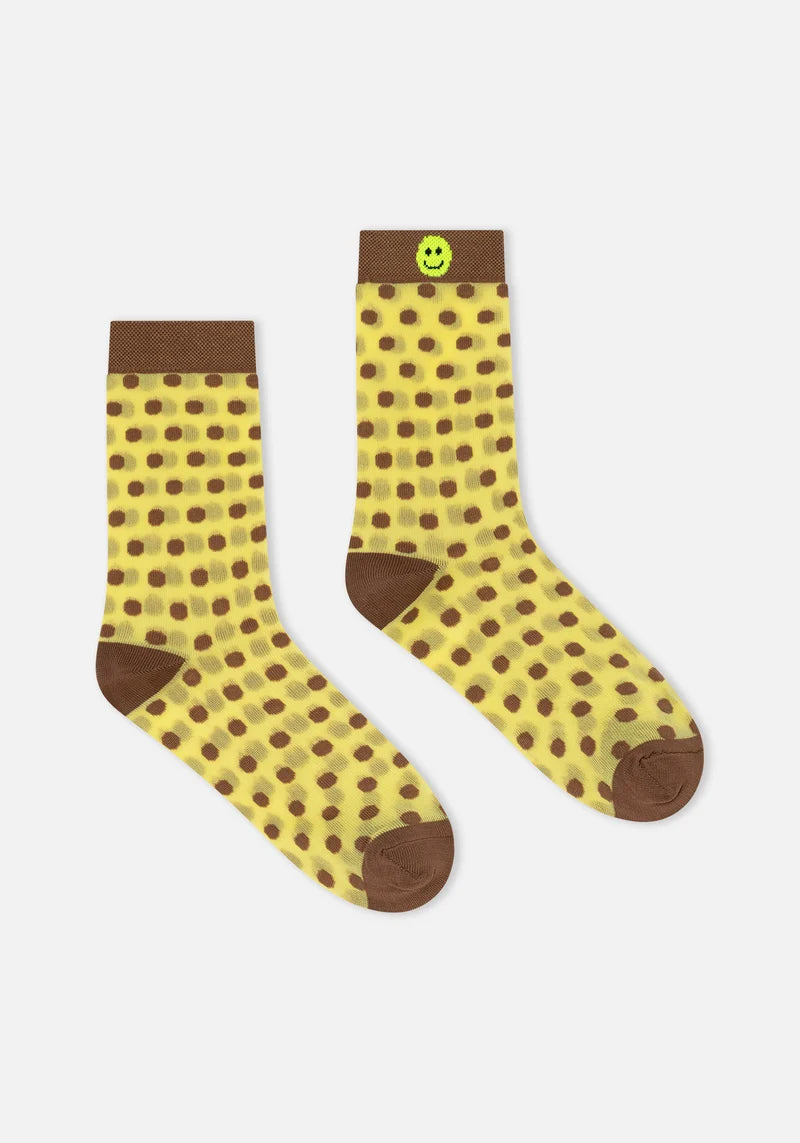 Pair of yellow socks with brown polka dots and brown accents on a white background