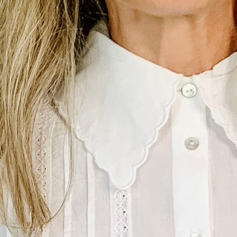 100% cotton white blouse. The scalloped detailing on the collar with the intricate and pleating details that run vertically down the front and arms of the blouse are stunning.