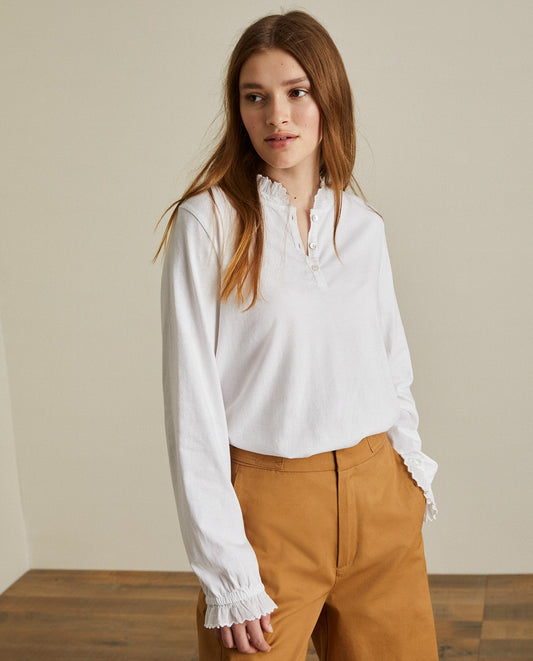 Cotton white shirt with long sleeves and embroidered neck. Decorative stitching on the sleeves and neck.