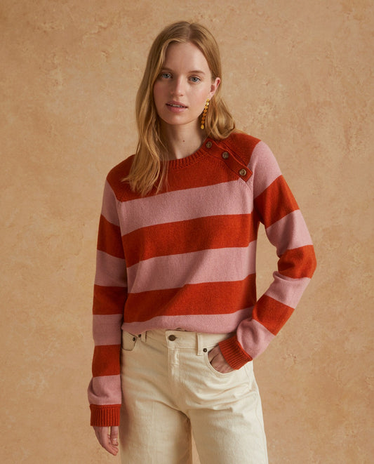 The beautiful Raya Sweater in pink and orange stripes features a round-neck with long sleeves and a 3 button detail on one shoulder.